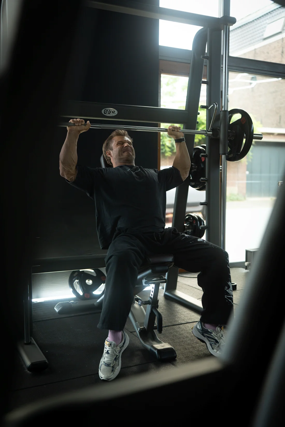 Sporter drukt een halterstang omhoog in de gym