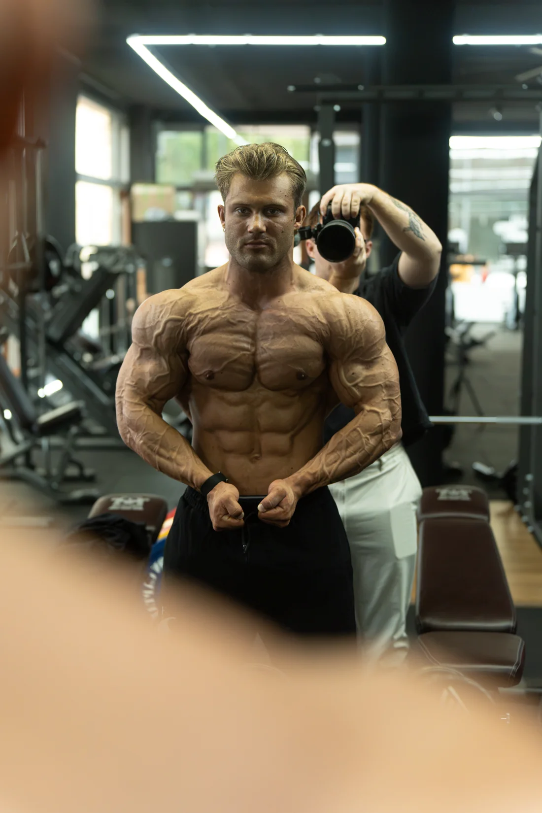 Atleet poseert voor de spiegel in de gym