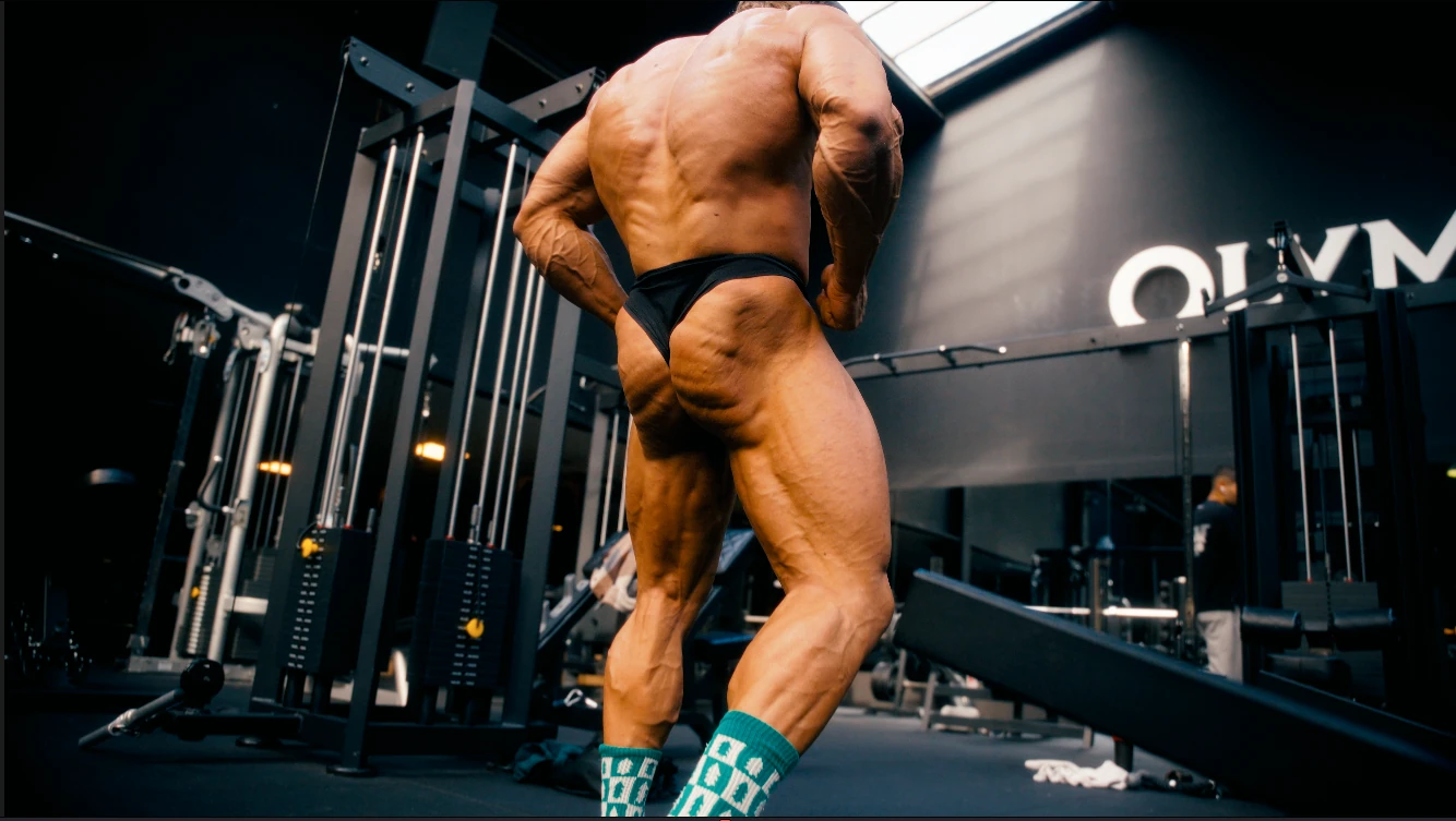 Detail van een bodybuilder van achteren, met de nadruk op rug en benen