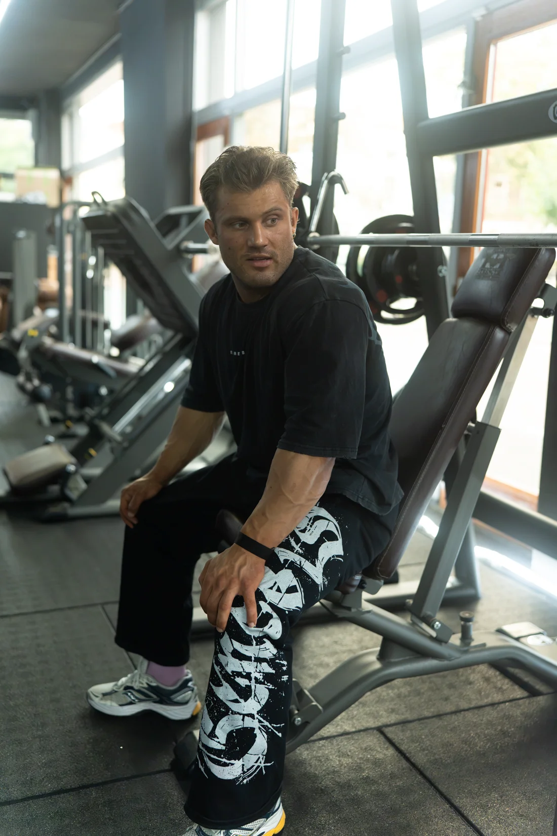 Sporter zit op een trainingsbank in de gym